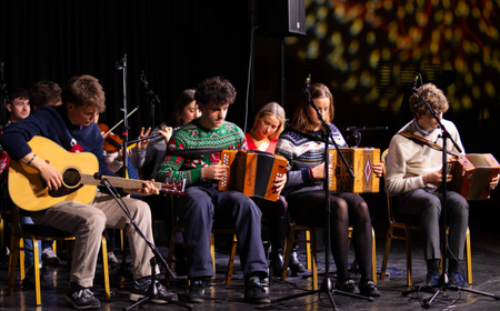 UCD students play traditional instruments, including guitar, fiddle and accordion, during a festive performance on stage at the Vet School Carol Service.